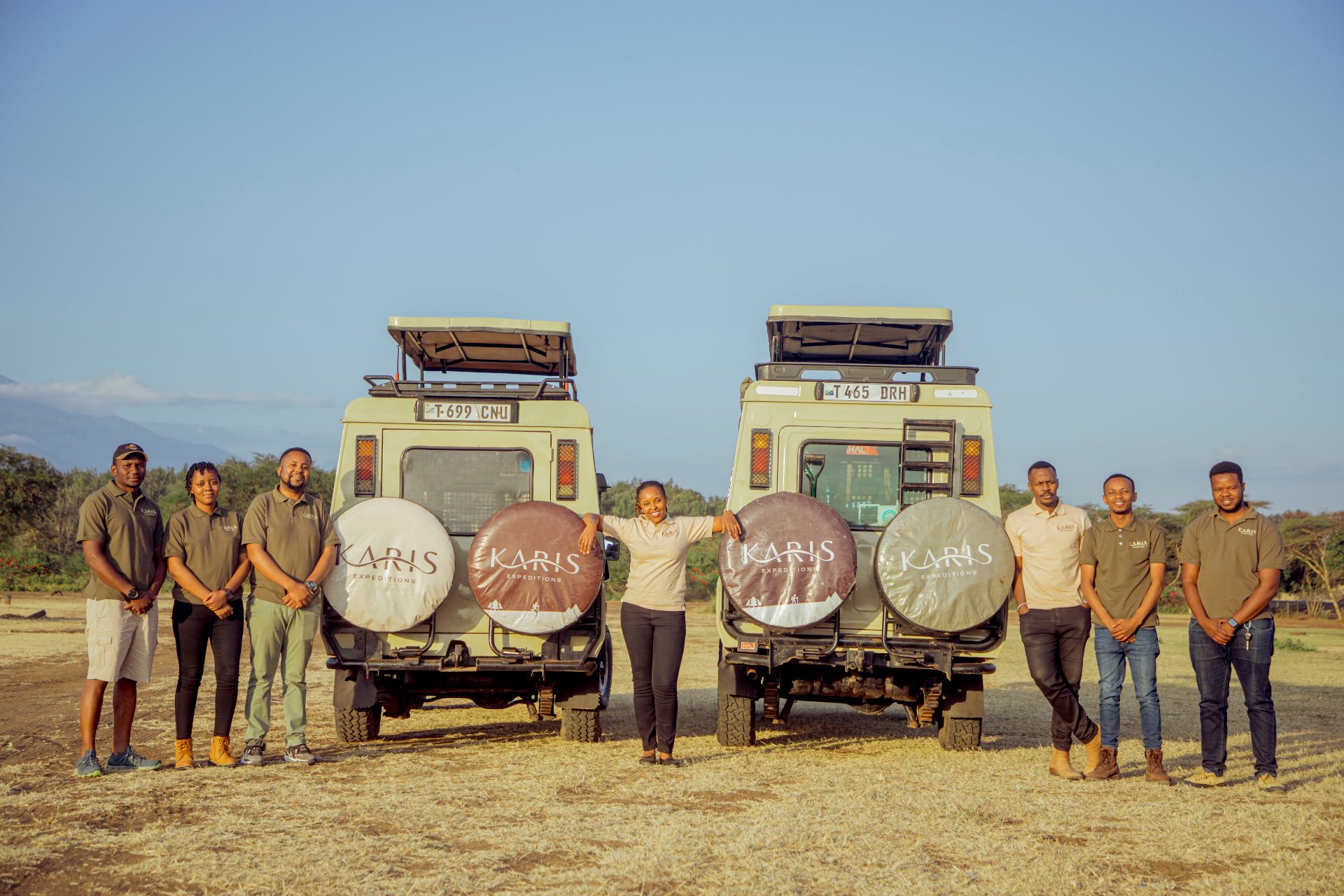The Karis Expeditions team beside our custom Toyota Land Cruisers in Arusha